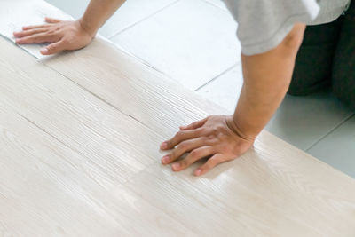 Hand installing vinyl flooring on the floor. diy, home improvement and industrial.