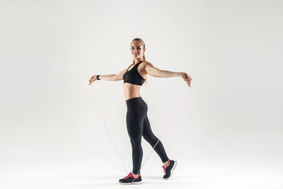 Full length portrait of woman standing against white background