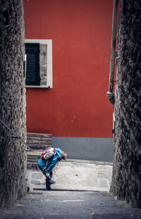 Man walking on footpath against building