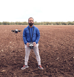 Portrait of young man standing on field