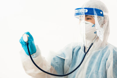 Doctor holding stethoscope against white background