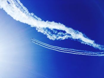 Low angle view of airshow in blue sky