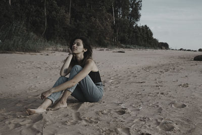 Portrait of young woman sitting on land