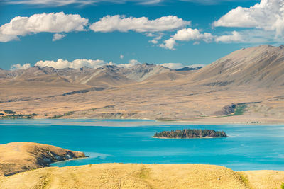 Scenic view of lake and mountains against blue sky