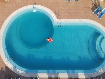 Aerial view of woman relaxing in swimming pool