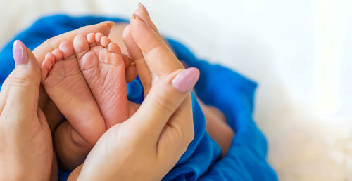 Hands of woman holding baby feet