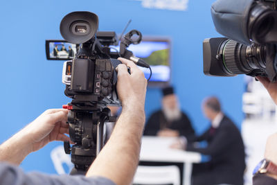 Cropped image of men filming news event with television cameras