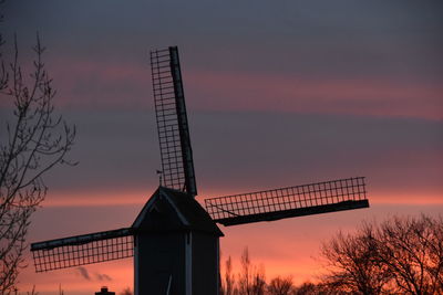 High section of windmill against clouds