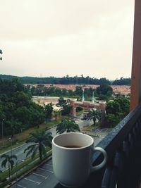 Coffee cup and buildings against sky