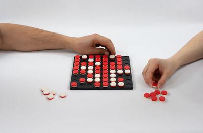 High angle view of woman hand holding red table against white background