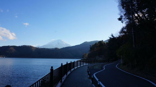 Scenic view of road by mountains against sky