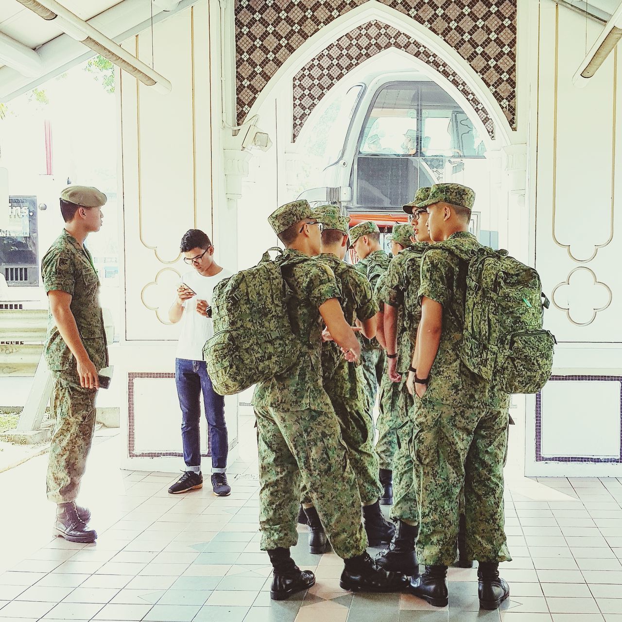 standing, full length, togetherness, day, medium group of people, indoors, men, real people, friendship, built structure, lifestyles, building exterior, group of people, architecture, military uniform, young adult, people