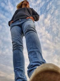 Low section of woman standing against sky