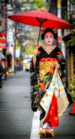 Portrait of woman with umbrella on street