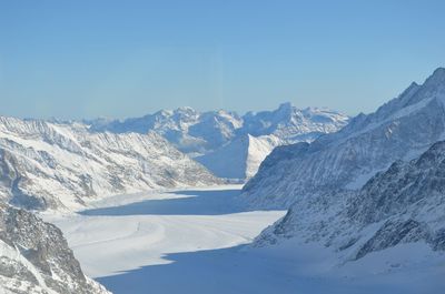 Scenic view of snowcapped mountains against blue sky