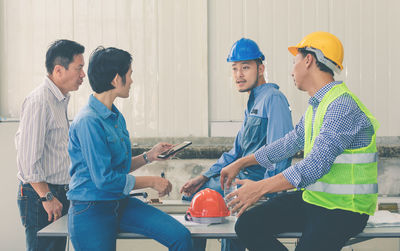 Architects discussing while sitting at desk