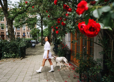 Portrait of woman with dog on footpath