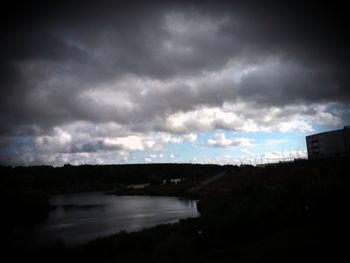 Bridge over river against cloudy sky