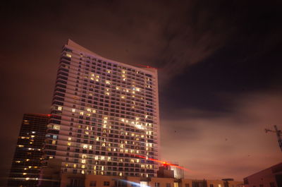 Low angle view of illuminated buildings against sky at night