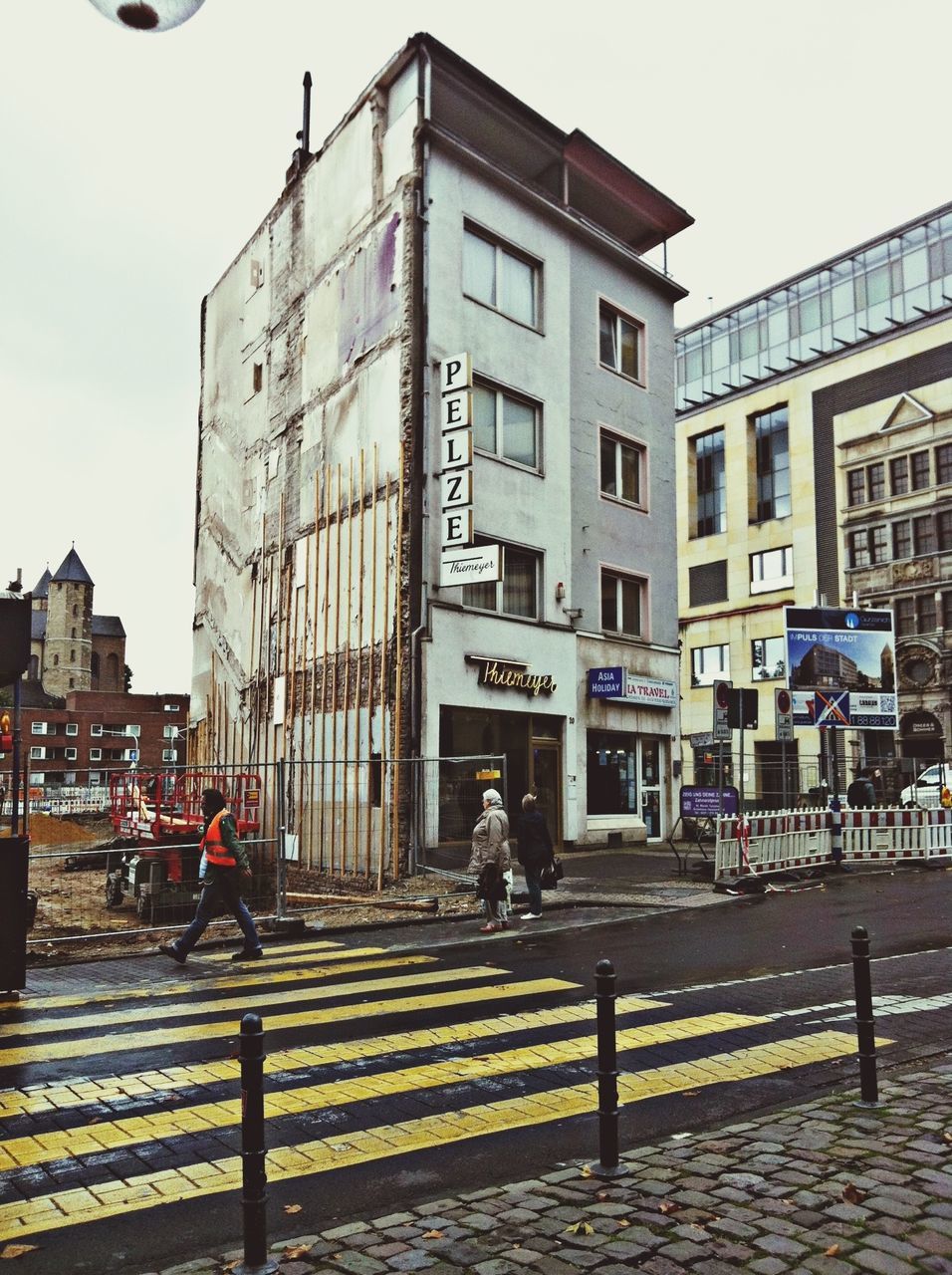 building exterior, architecture, built structure, city, street, building, men, city life, walking, window, person, lifestyles, residential building, city street, residential structure, sky, transportation, full length, day