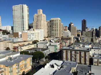 Buildings in city against blue sky