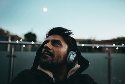 Portrait of man looking away against sky