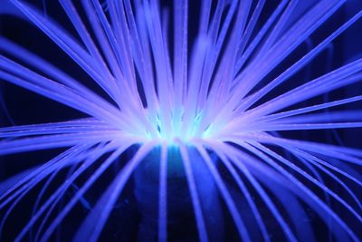 Close-up of illuminated lighting equipment against black background