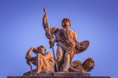 Low angle view of angel statue against clear blue sky