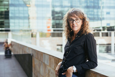 Portrait of young woman standing in city