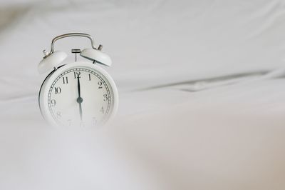 Close-up of clock on bed