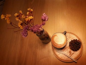 High angle view of flower vase by coffee on table