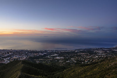 Aerial view of city against cloudy sky