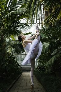 Full length of woman dancing on palm trees