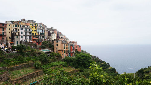Residential district by sea against clear sky