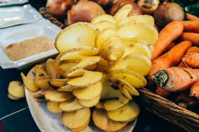 Close-up of sliced potatoes by carrots and onions