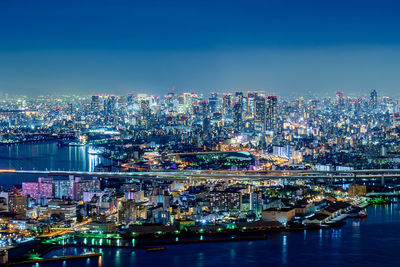 High angle view of illuminated cityscape against sky at night