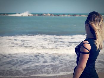 Side view of woman standing at beach