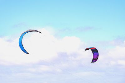 Low angle view of person paragliding against sky