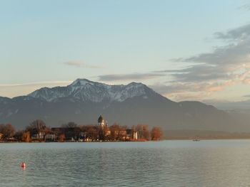 Scenic view of lake by mountains against sky