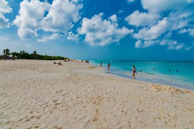 People at beach against sky