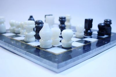 Close-up of chess pieces on board against blue background