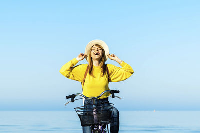 Woman standing by sea against clear sky