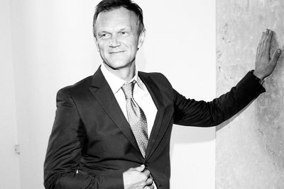 Portrait of smiling young man standing against wall