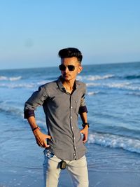 Portrait of young man standing at beach