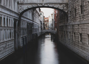 Bridge over canal amidst buildings in city