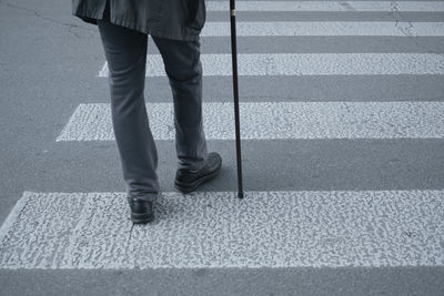 Low section of man walking on road