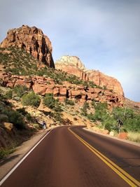 Road leading towards mountain against sky