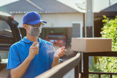 Portrait of man holding ice cream standing outdoors