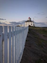 Lighthouse by sea against sky