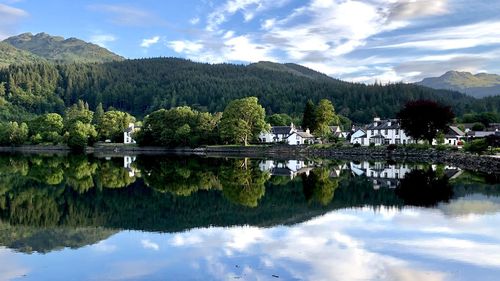 Scenic view of lake by trees against sky